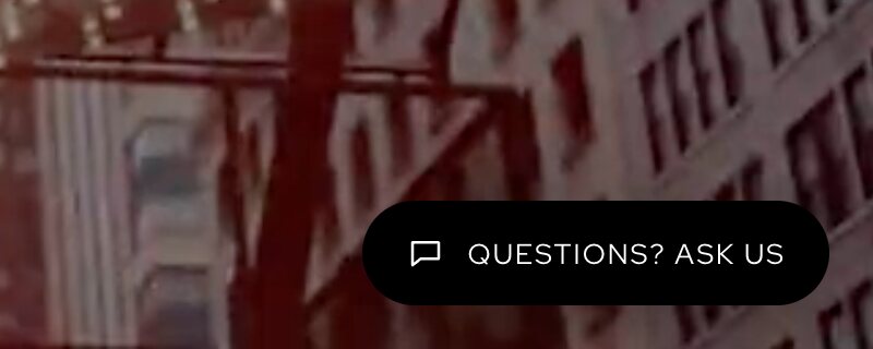 The corner chat bubble reading Questions? Ask us over the home page hero